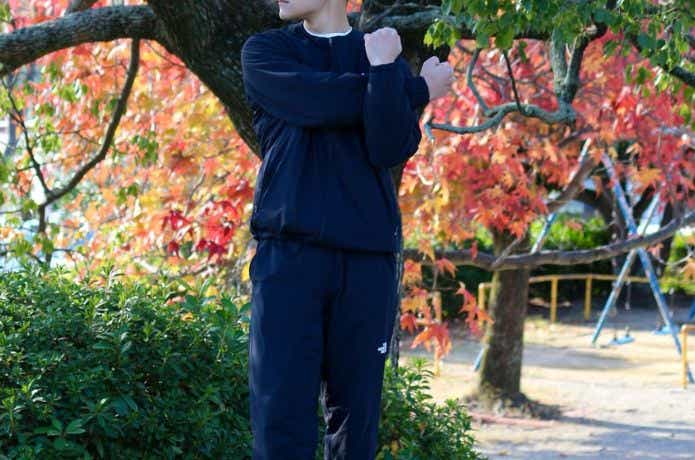黒いザ・ノース・フェイスのインナーダウンをきてストレッチする男性