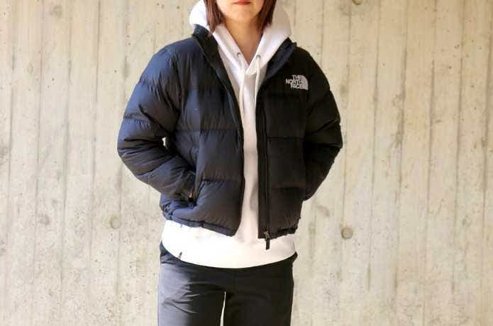黒いザ・ノース・フェイスのダウンを着る女性