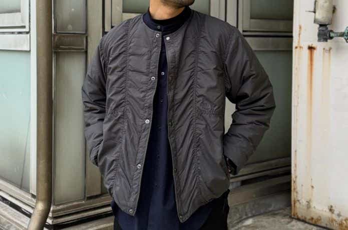 ザ・ノース・フェイスのグレーのインナーダウンを着る男性