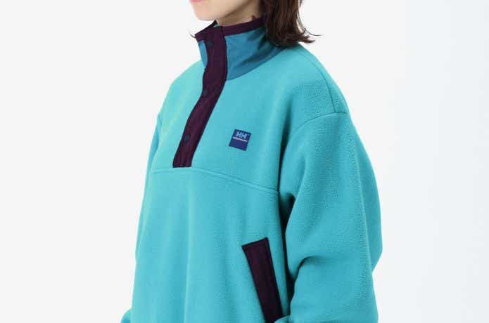 水色のヘリーハンセン トータルシーウエアコンセプト フリースプルオーバージャケット（ユニセックス）を着た人