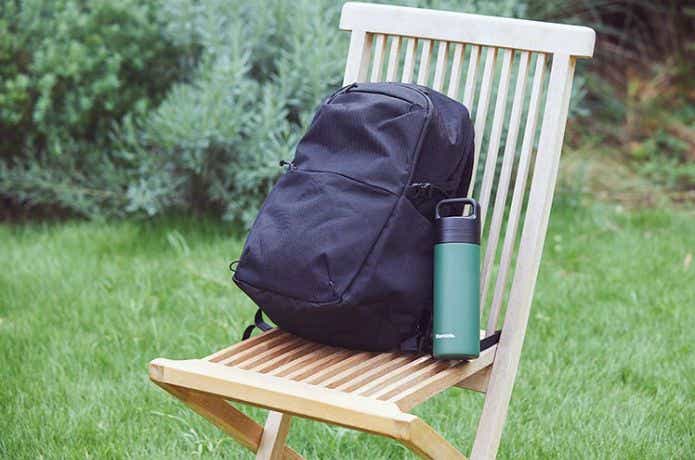 椅子の上のリュックの隣にビタントニオ コーヒープレスボトルを置く