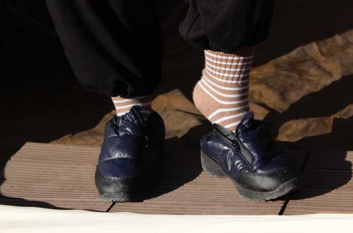 ジッパーを2/3開けて足を入れている