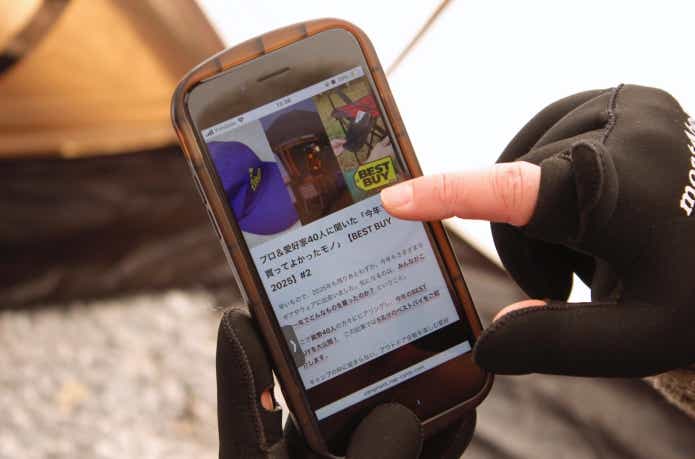 指を出してスマホを操作している