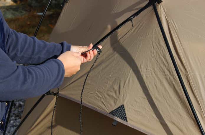 冬のキャンプで素手でロープを張っているところ