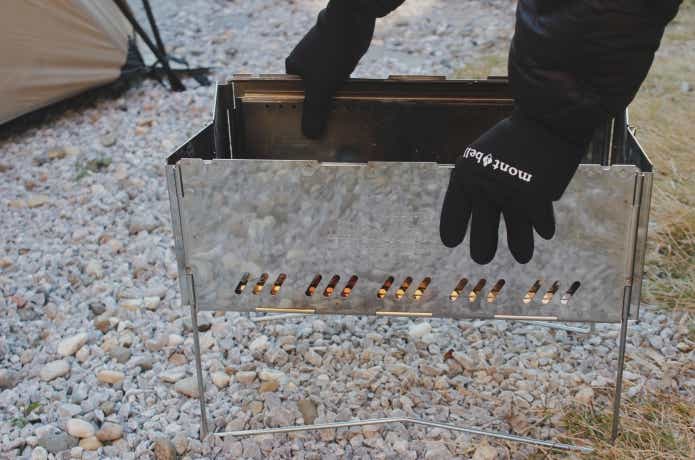 クリマプレンフィッシンググローブ着用で焚き火台を広げている