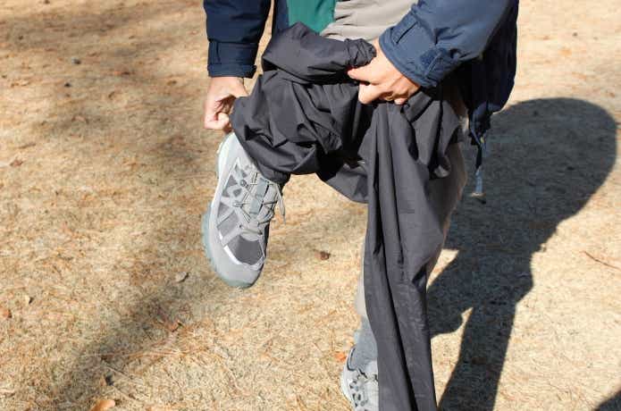 シューズを履いたままU.L.ストレッチウインドパンツをはくところ