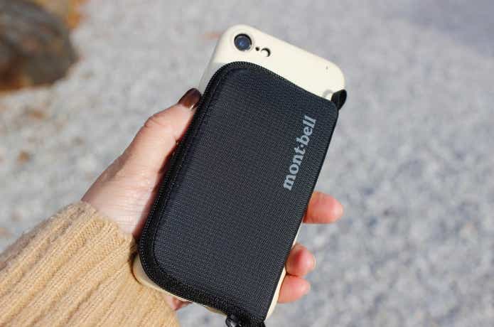 スマホとMagSafe化したモンベル財布を片手で持っている