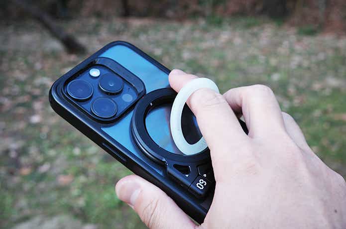 aulumuのスマホリングに指を入れて持ったiPhone