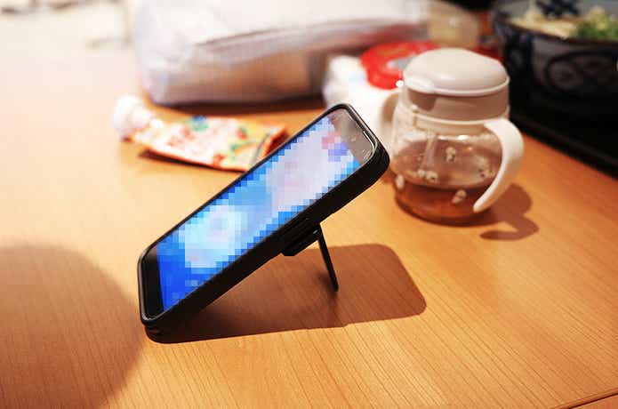 aulumuのスマホリングを貼り付けた卓上のiPhone