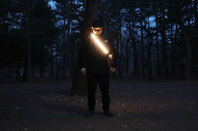 体にたすき掛けをしたハンギングテープライト