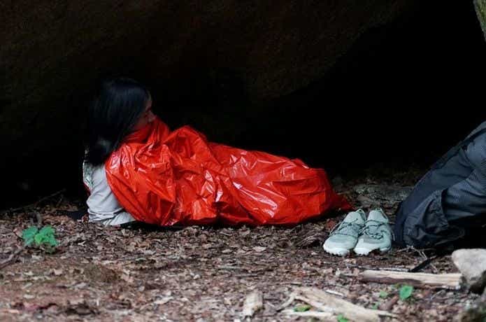 エマージェンシーシートにくるまって寝る女性