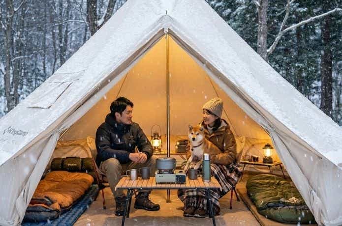 冬にキングキャンプ ベルテント 4mの中でくつろぐ人