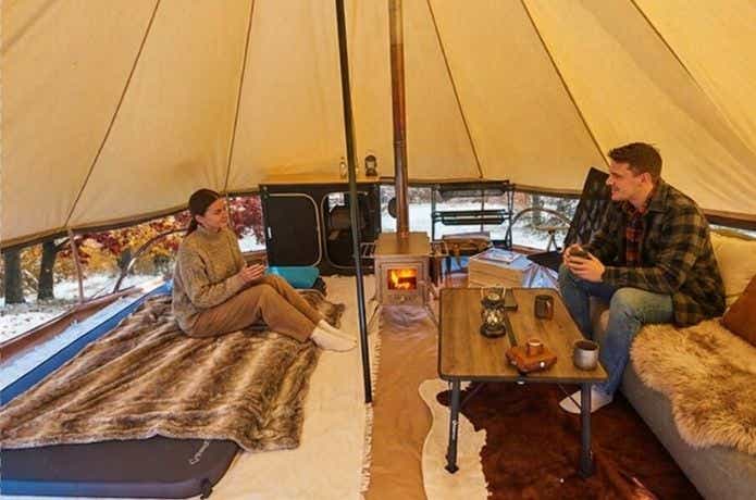 キングキャンプ ベルテント 4mの中でくつろぐ男女