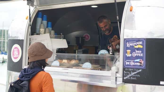 キッチンカーで買い物をする女性