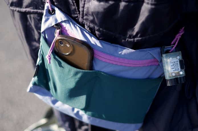 外側ポケットにスマホを入れている