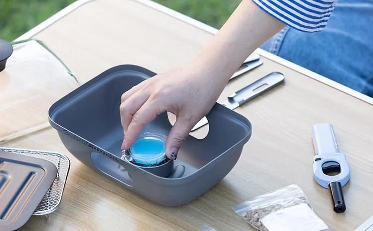 アドバンダーの燻製器「マジックボックス」に固形燃料をセットする様子