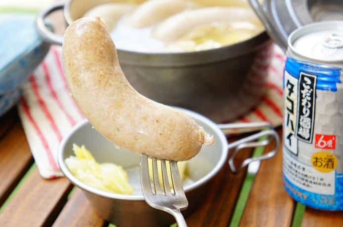 業務スーパーの「こだわり生フランク（プレーン）」をフォークで挿しているところ