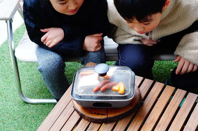 アドバンダーの燻製器「マジックボックス」を観察する子供たち