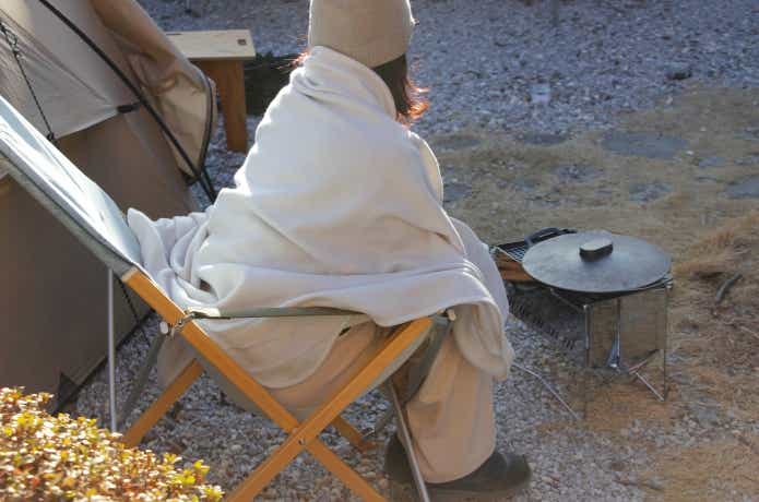 難燃毛布を焚き火のそばで使っているところ