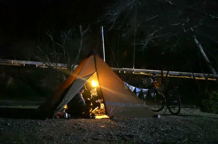 ティピテントでキャンプをしている男性