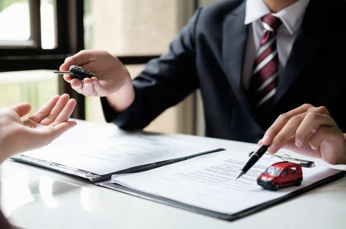 スーツを着た人から鍵を受け取る写真