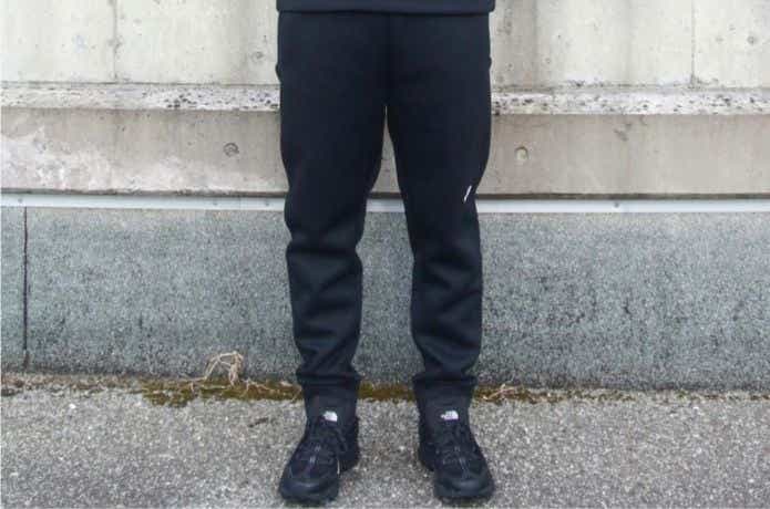 黒いザ・ノース・フェイスのパンツを履く人