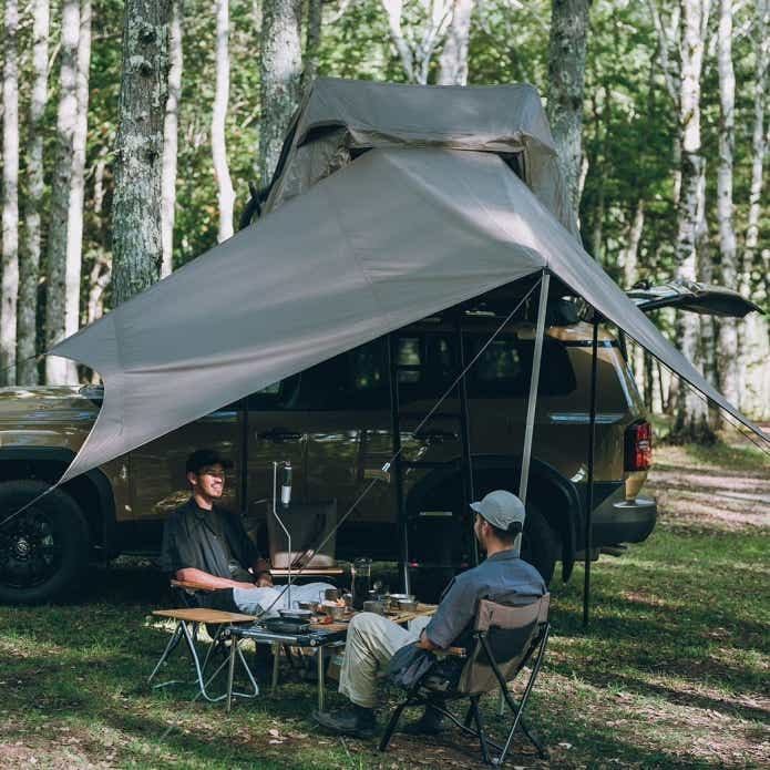 スノーピーク「フィールドライズ」付属のタープでくつろぐ人