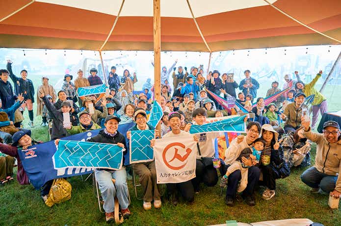 田中陽希さんとたくさんの人たちが手ぬぐいを持っている写真