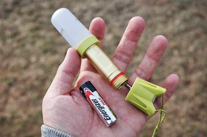 手のひらに乗ったモンベルのミニランタンと電池