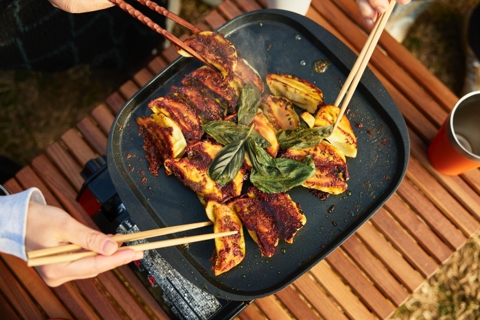 カレー味の餃子を箸で掴んでいる写真