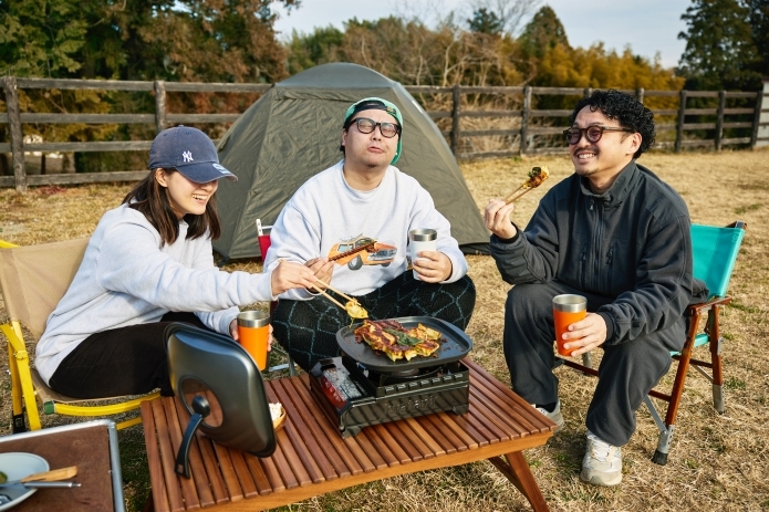 グループキャンプで餃子を食べている男女