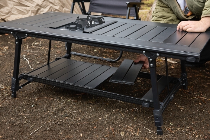 キャンプテーブルの下部に物を置くスペースを作っている写真