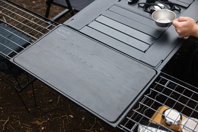 キャンプ用の黒いテーブルを展開して広げている写真