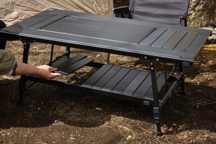 キャンプテーブルの下部に物を置くスペースを作っている写真