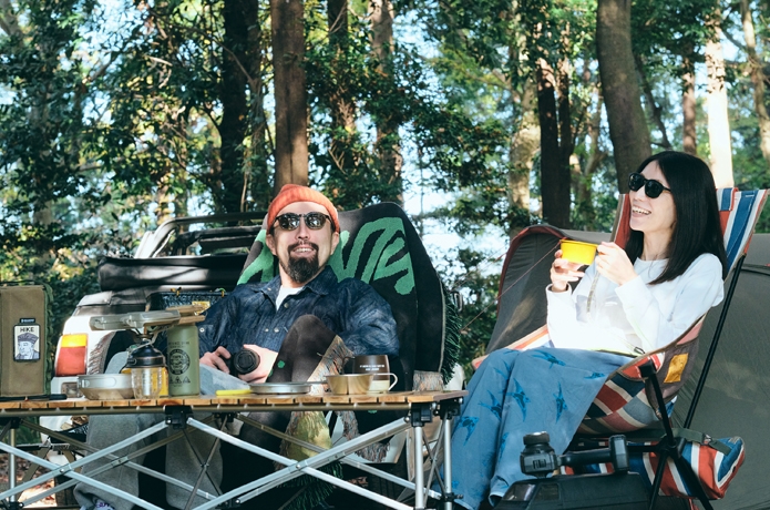 サングラスをかけ、キャンプを楽しんでいる男女