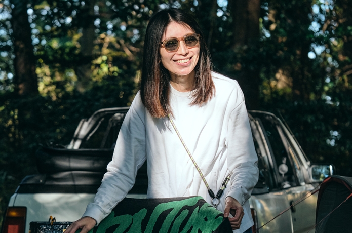 ソライズのサングラスSLD-006のブラウンをかけ、椅子に手をかける女性