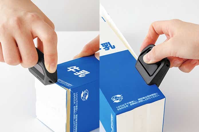 ボックスカッターで牛乳パックを解体している