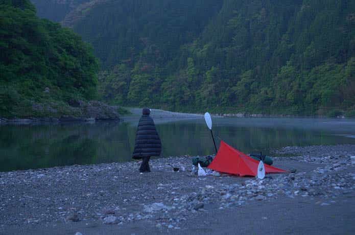 湖畔キャンプでブランケットを羽織っている男性