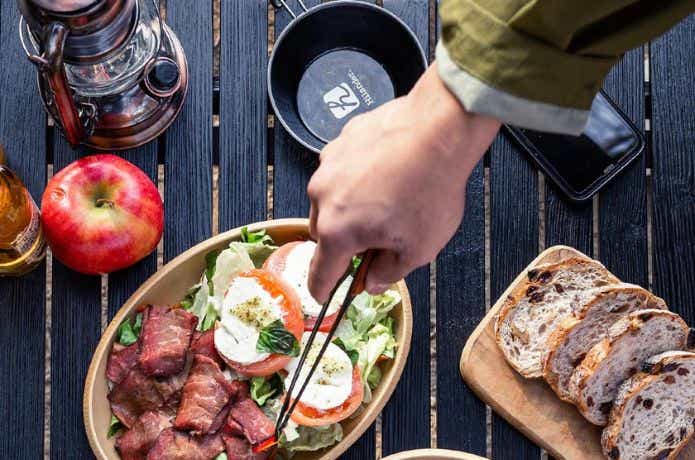 ハイランダー ウッドロールトップテーブル light 120の上に料理をのせる