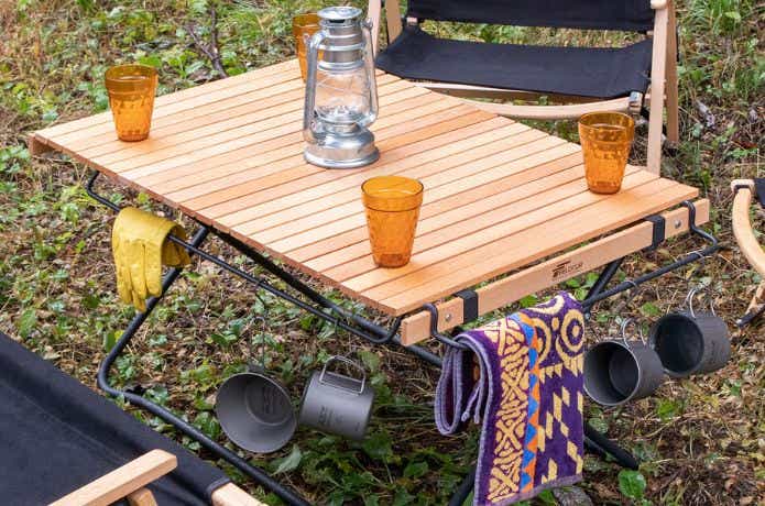 フィールドア ウッドロールトップテーブルスチールレッグの上にアウトドアアイテムをのせる