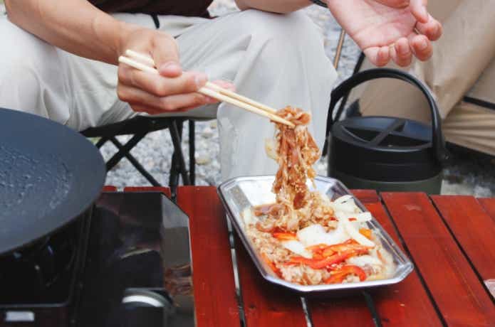 つなげて使える竹丸箸で生肉を掴んでいる