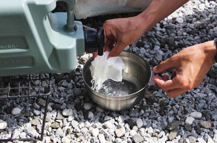 ポリタンクの水でキッチンペーパーを濡らしているところ