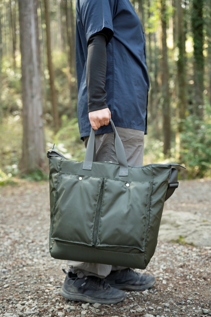 クーラーバッグを片手で持つ女性