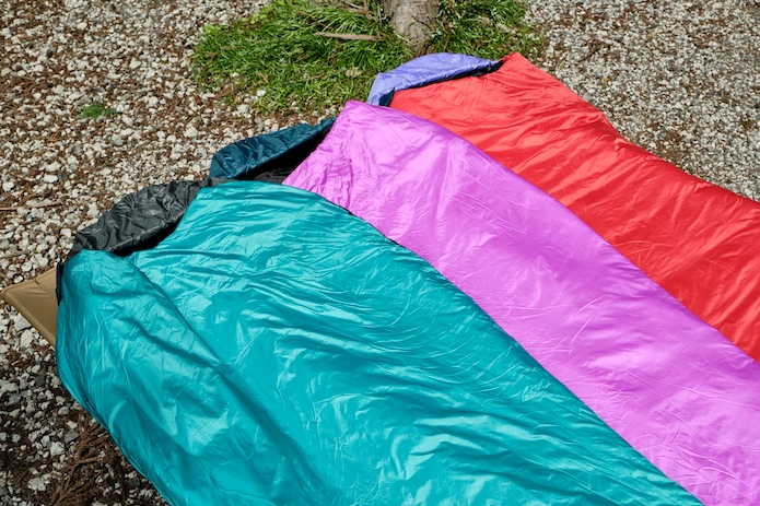 緑、ピンク、赤の寝袋