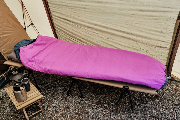 NANGAのピンク色の寝袋がコットの上に乗っている写真
