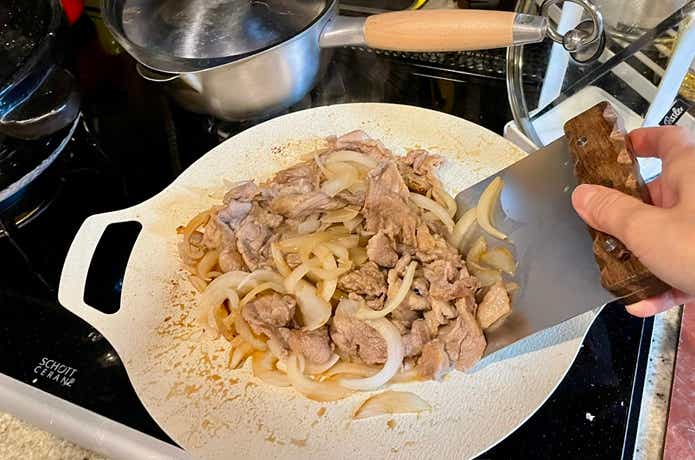 グリドル調理したおかずをキャンピングムーンのスクレーパーで混ぜている
