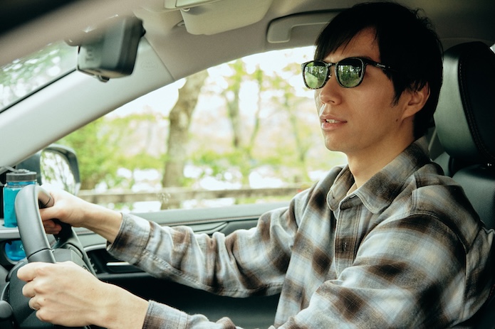 サングラスをかけて車を運転する男性