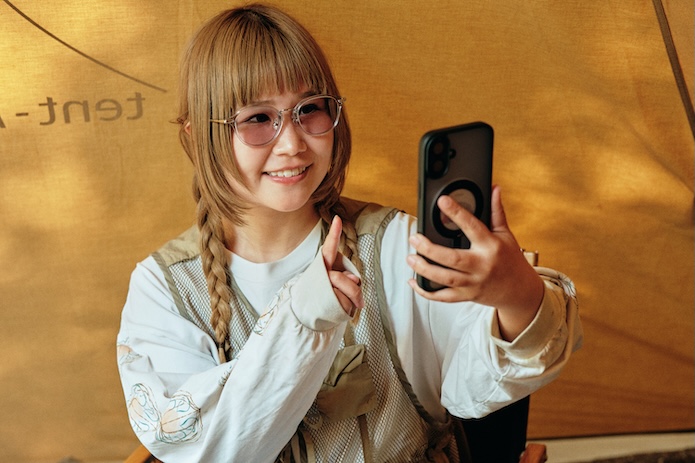 サングラスをかけてスマホを見る女性