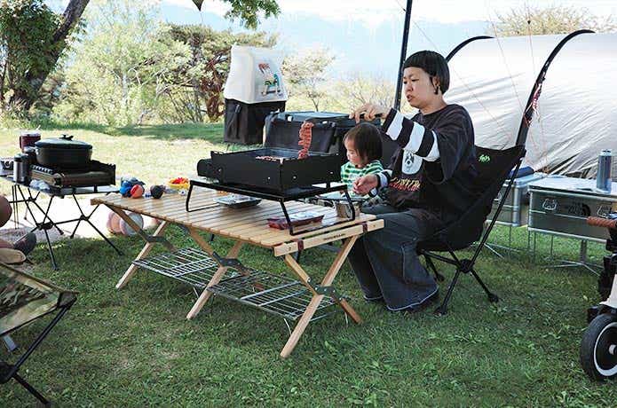 ラックに上に載せた焼き上手さんで調理をする女性