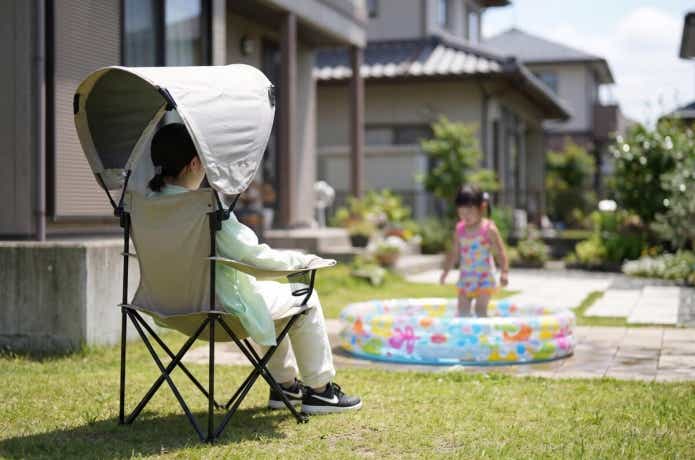 屋根付きアウトドアチェアに座っている女性